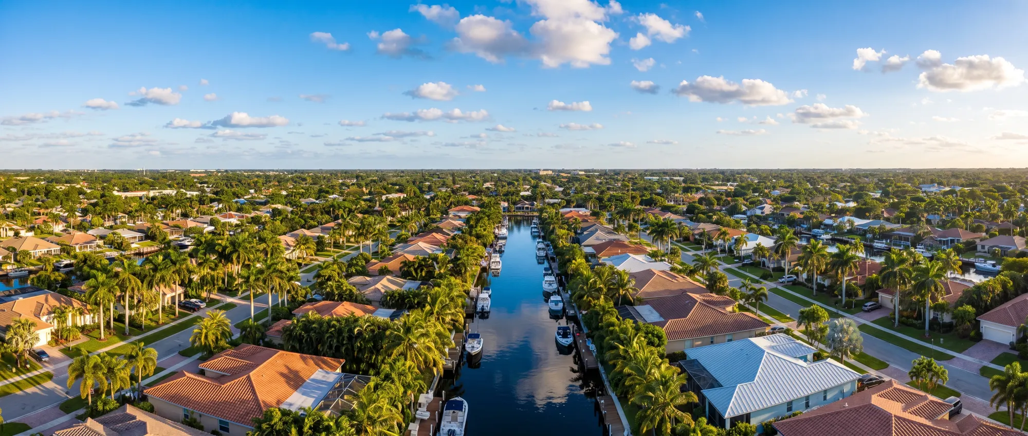 Aerial view of a South Florida canal neighbourhood of tile and metal roofs